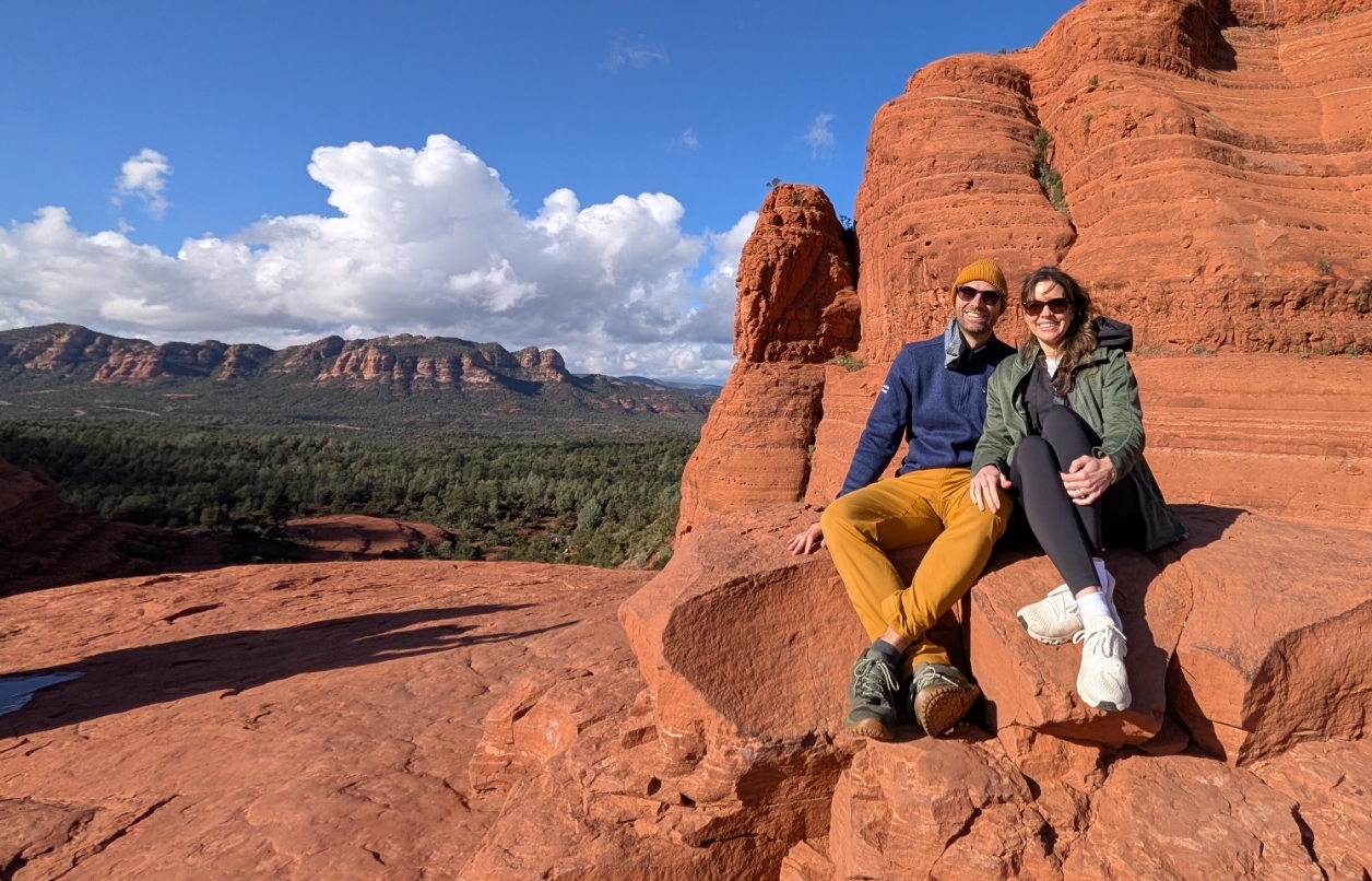 Laura and Mike sitting on red rocks in Arizona